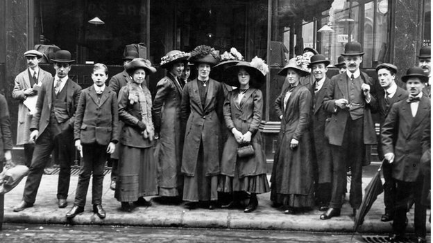 feuille-d-automne:   Group of smartly dressed people standing outside a tailors