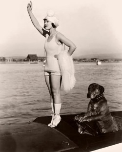 Gloria Swanson (1899 - 1983) stands on tiptoes
