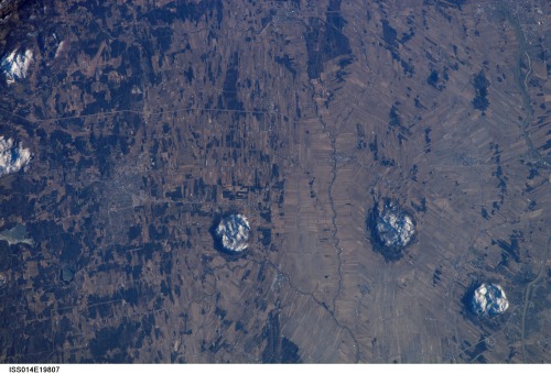 PlutonsThis photo from the International Space Station looks down at three blisters on Earth’s surfa