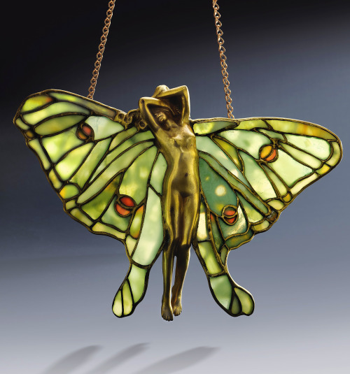 kafkasapartment:Rare figural lamp screen. Created by Tiffany Studios, c.1905.Leaded glass, gilt bron