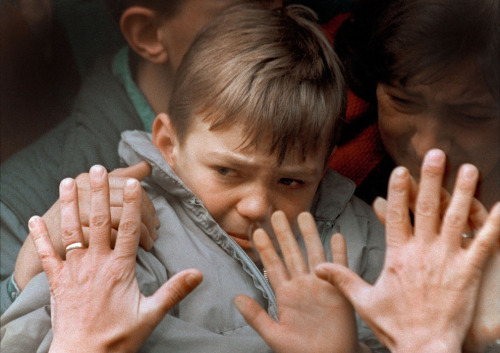 collectivehistory:A father’s hands press against the window of a bus carrying his tearful son 