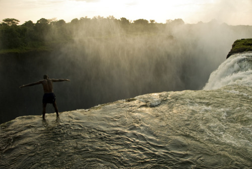 unrar:Looking over the edge of Victoria Falls from a swimming hole, Zambia, Annie Griffiths.