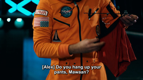 [ID: Four screencaps from Taskmaster. Mawaan Rizwan hangs a pair of orange boxer shorts from a trous