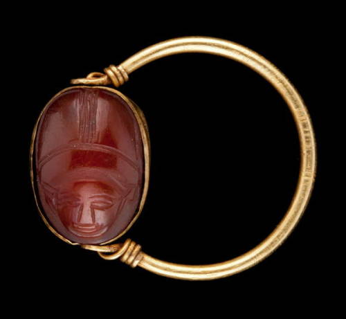 egypt-museum:Carnelian Scarab RingAncient Egyptian carnelian scarab with human face set in a gold ri