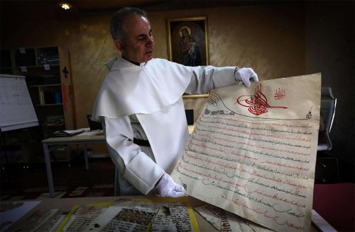 Najib Mikhael Moussa O.P. displays a manuscript at the Oriental Manuscript Digitisation Centre (CNDO