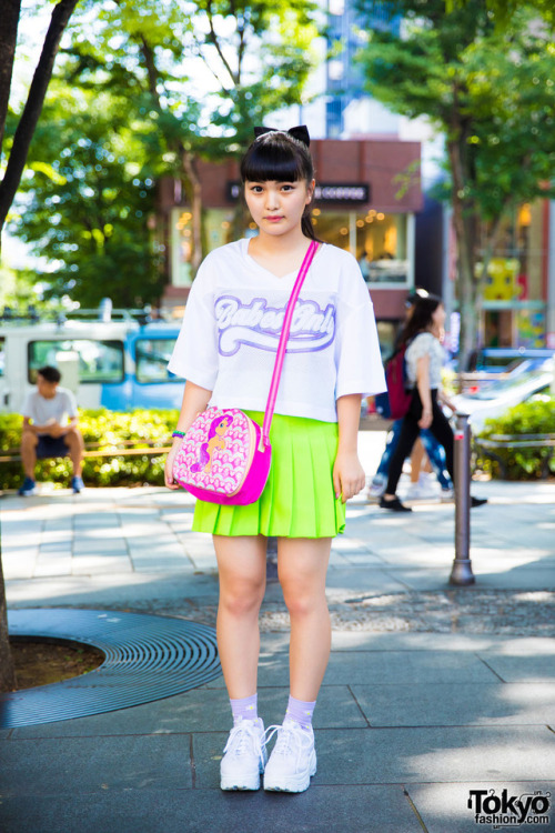 14-year-old Sarasa on the street in Harajuku wearing a cute style with a graphic tee, neon skirt, sn
