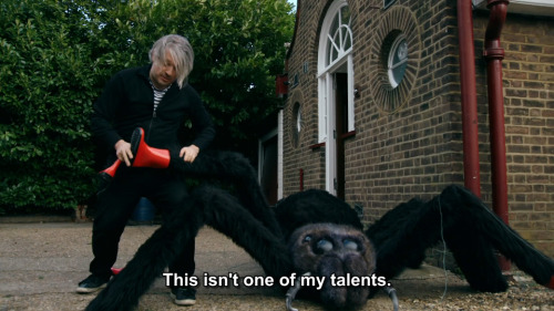 [ID: Two screencaps from Taskmaster. Richard Herring is in a garden, putting red wellington boots on