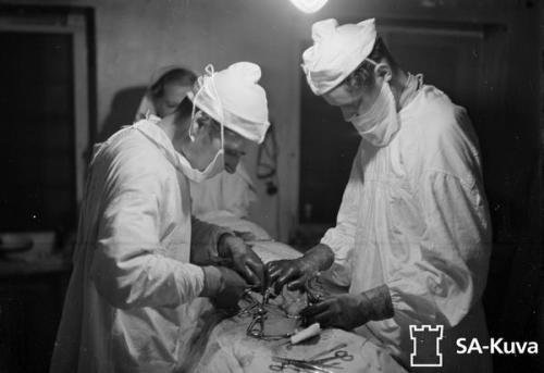 Real life M*A*S*H unit surgeons performing abdominal surgery on...