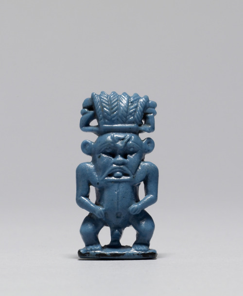 Ancient Egyptian protective amulet (faience with dark blue glaze) of the protective god Bes.  Artist