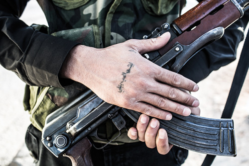 hellosyria:   Love in the time of war A FSA soldier bares his tattoo, which says: “Why is love disastrous?”  