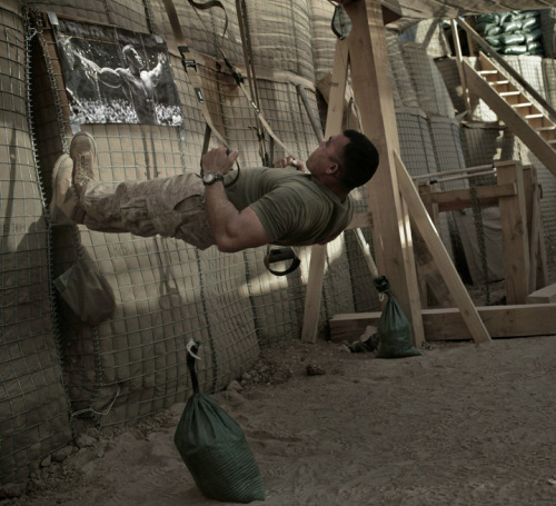 relentless-carlos:  bossfit:  A US Marine from India Company, 3rd Battalion, 6th Marines, works out in front of an Arnold Schwarzenegger poster in southern Afghanistan. Improvised gym materials include sandbags, truck chains and ammunition cases. View
