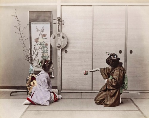 Two Japanese girls playing with a ball (c.1890).  In the background are a flower arrangement, a hang