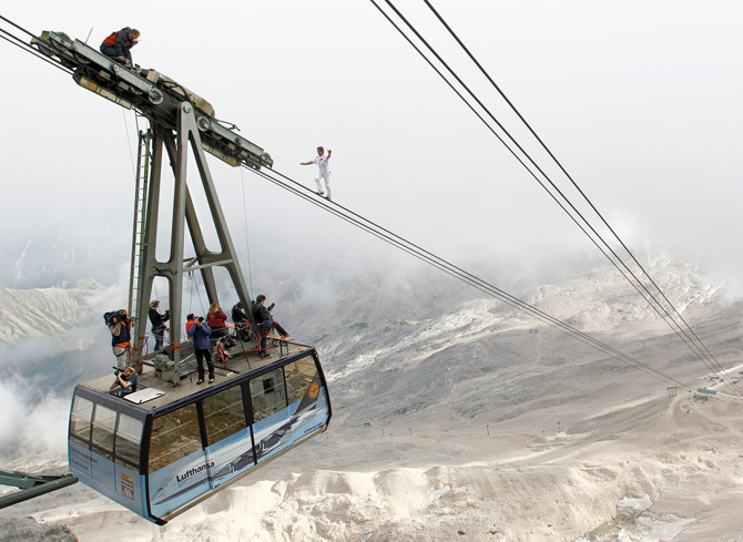 sixpenceee:Germany: High above Bavaria’s Zugspitze mountain, Swiss tightrope artist