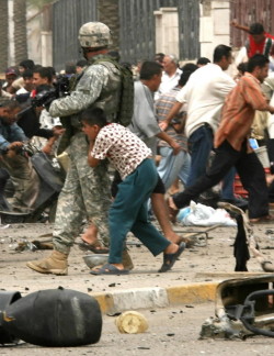 gunslinger-gentlemen:jjrtx:militaryarmament:A boy seeks shelter behind a soldier with the U.S. Army’s 82nd Airborne division after gunshots rang out at the scene where a suicide car bomber blew himself up in central Baghdad on Monday, May 28, 2007.