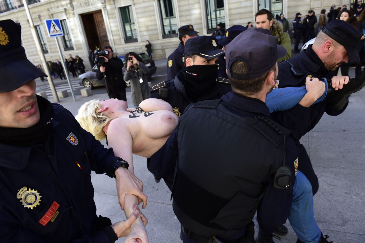 ESPAÑA. Dos activistas de Femen protestan frente al Congreso contra la ‘ley mordaza’al grito de “Protestar no es ilegal” y con los lemas “Femen for freedom” y “España sin mordaza” escritos en el torso y en la espalda desnudos. (AFP)