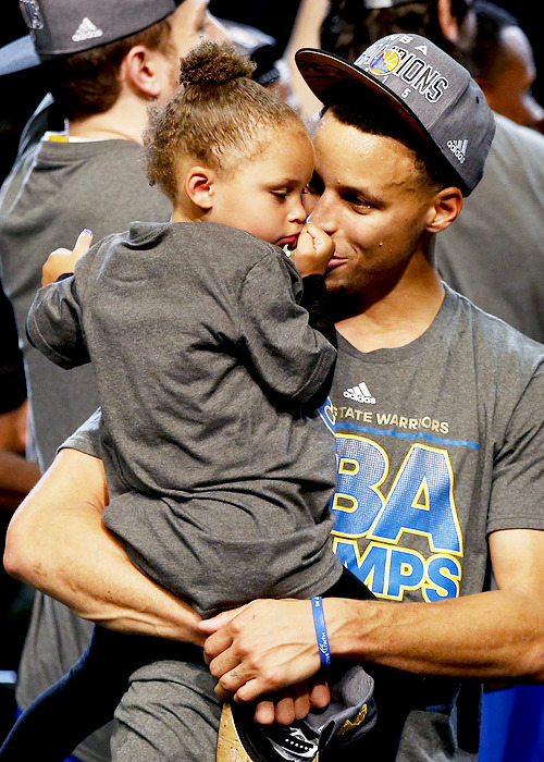 celebritiesofcolor:  Stephen Curry #30 of the Golden State Warriors celebrates with Riley after defeating the Cleveland Cavaliers in Game Six of the 2015 NBA Finals at Quicken Loans Arena on June 16, 2015