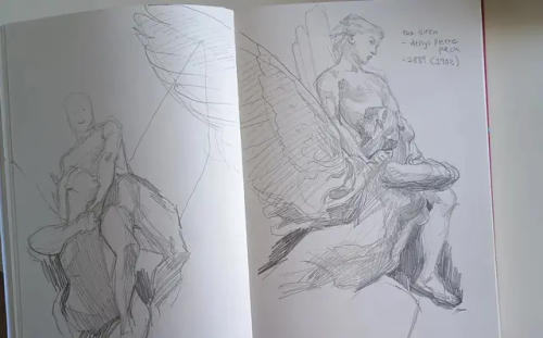 a picture of a sketchbook with two pencil studies of a statue, "the siren" by Denys Pierre Puech, from two angles. the statue shows a siren flying forth with a young man held on her shoulder.