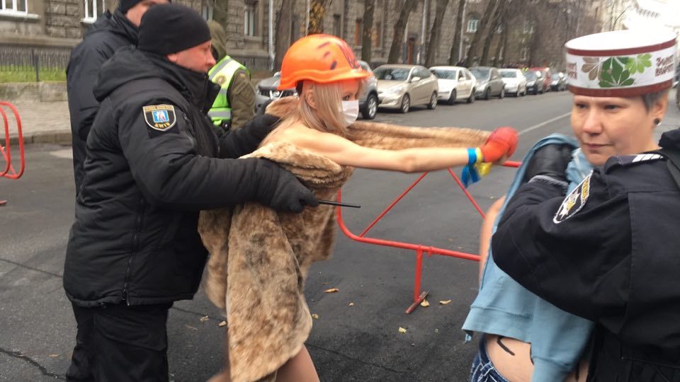 PROTESTA EN KIEV. Policías detienen a activistas en topless del grupo de derechos de las mujeres Femen durante una protesta contra el presidente ucraniano Poroshenko en Kiev, Ucrania, el cuarto aniversario de la Revolución de la Dignidad....