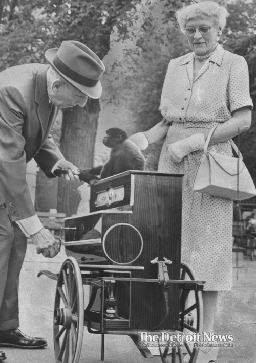 An organ grinder and his monkey work Belle Isle in 1959 as a park visitor looks on. More historic st