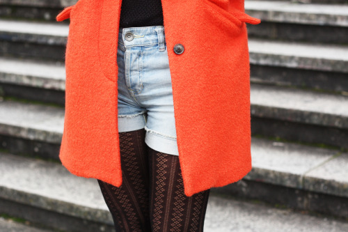 An orange coat, denim shorts and classic patterned tights are the perfect mix for a vintage, casual 