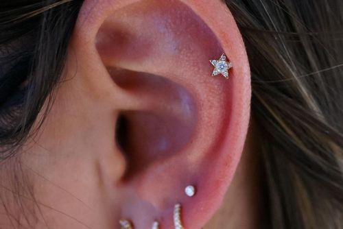 Healed helix piercing showing off a gold star with diamonds. Piercing performed @buddhaboxstudios(at