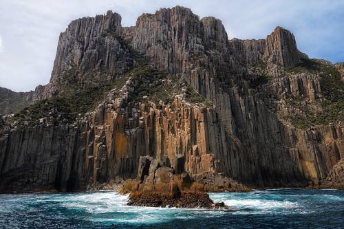 tasmaniabehindthescenery:Dwarfed by the towering cliff faces of the Tasman Peninsula. @JasonLStephe