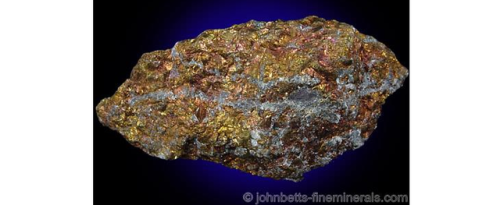 Copper-coloured bornite mass with a grey quartz vein running through it.