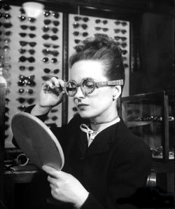 wehadfacesthen:  Maeve Brennan of Harper’s Bazaar trying on wooden-framed eyeglasses, 1945, photo by Nina Leen for LIFE magazine 