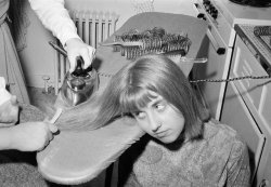 historicaltimes: Girl having her hair ironed