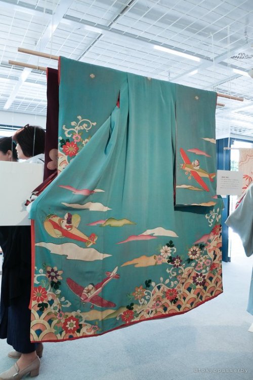 Antique pre wwii woman, kimono, with cute planes in a radiant sky (seen on). The overall joyfull fee