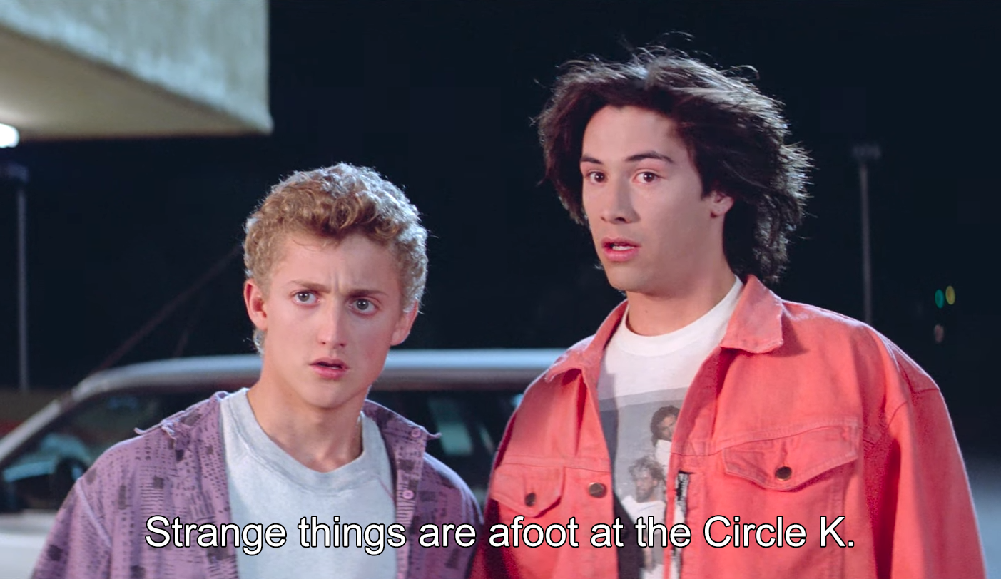 bill and ted from bill and ted's excellent adventure. ted leans toward bill, saying: "strange things are afoot at the circle k."