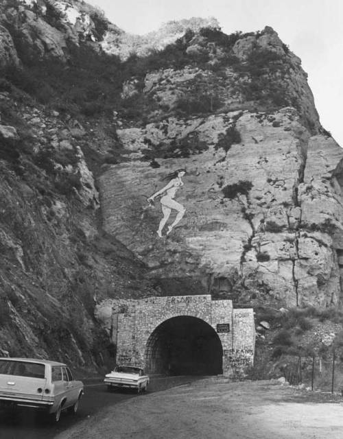 zeezrom:   “The Pink Lady of Malibu” “On October 29, 1966, a massive 60-foot-tall painting of a nude pink lady holding flowers suddenly appeared as you headed into the tunnel on Malibu Canyon Road. As word of the massive pink lady spread, and
