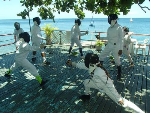 modernfencing: [ID: sabre fencers in whites, practicing on a deck next to the sea.]Fencing in Domini