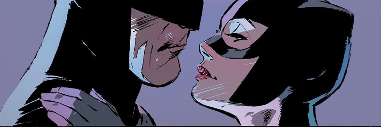 A photo of Batman (Bruce Wayne) and Catwoman (Selina Kyle). Catwoman is looking up at Batman with her hand on his shoulder as if they're about to kiss.