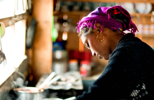 Biru cooking for guests in the early morning at Hotel Tibet Mountain View in Cholangpaty, Rasuwa, Ne