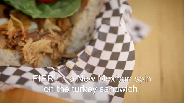 89% sure it's a close up of food on a table. Caption: FIERI: ...a New Mexican spin on the turkey sandwich.