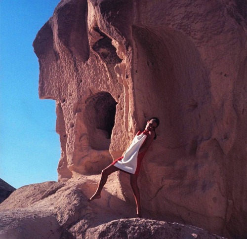 isabelcostasixties:Model near cliff dwellings at Gereme, Turkey, wearing red sleeveless linen dress 