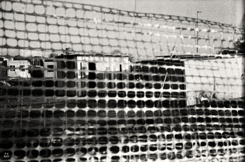 Construction fence Olympus 35SP on expired Fuji color film, B&W retro edit.