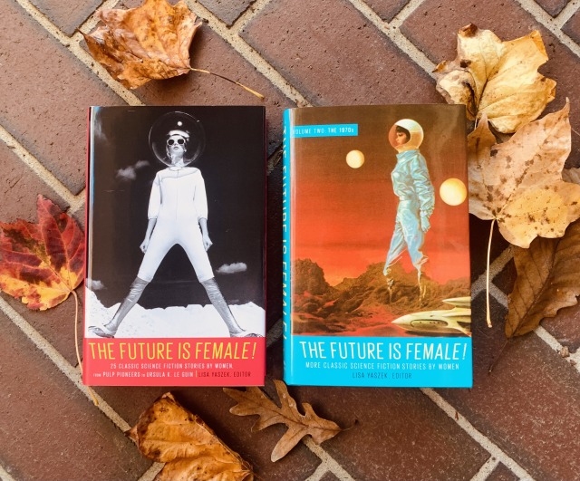 This is a photo (on bricks, surrounded by autumn leaves) of the two The Future Is Female! volumes of science fiction by women from Library of America, edited by Lisa Yaszek. Both have cover art depicting women astronauts.