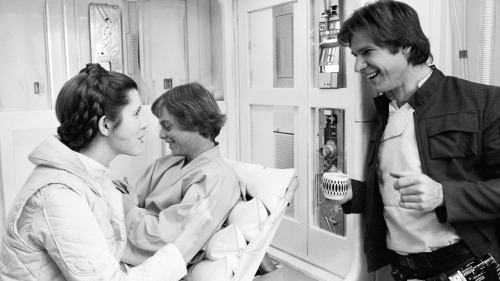 Hamill (in back) smiles as Carrie Fisher and Harrison Ford converse on the Hoth infirmary set, where