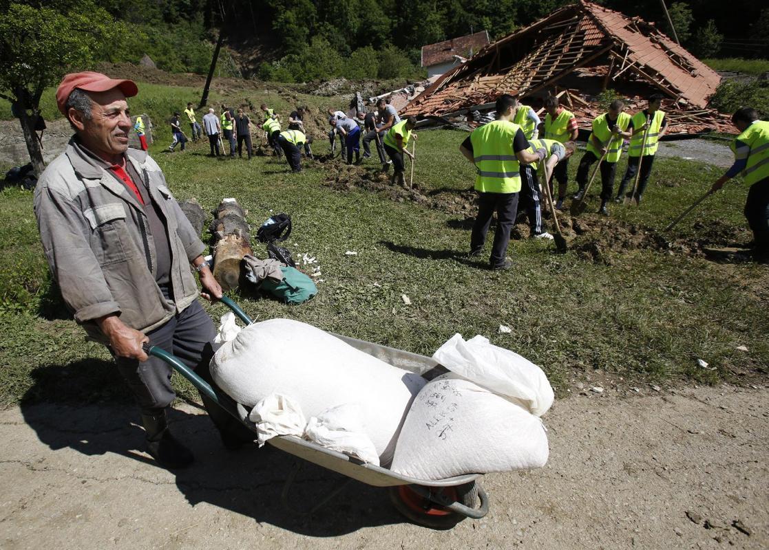 merosezah:  1. A Serbian rows a boat past flooded ambulance vehicles in the flooded