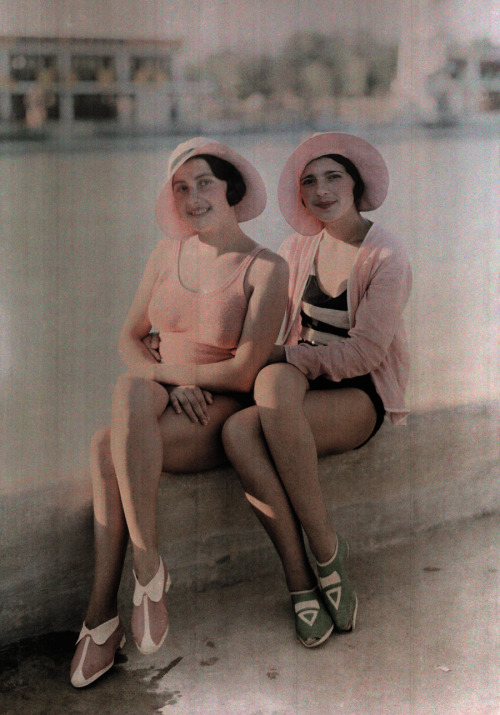 Two girls in bathing suits sit on a concrete ledge in Bucharest, Romania, November 1930.Photograph b