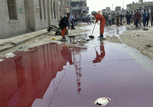 Porn photo losed:  Iraqi workers clean debris near a