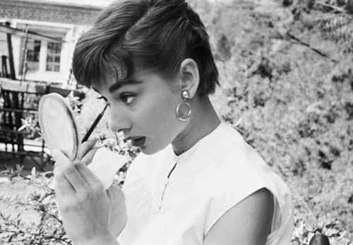 Audrey Hepburn gives herself a last minute touch up on the set of Sabrina. Outtake from the photo es