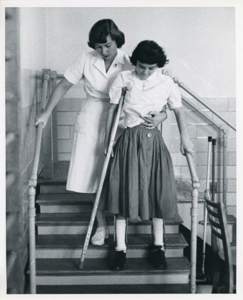 Polio girl learning how to go down stairs in KAFO braces