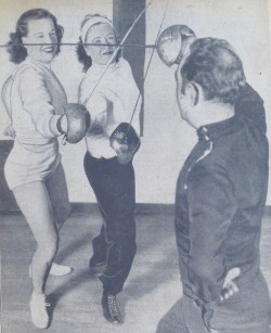 modernfencing: [ID: a sabre coach parrying five against two students at once. All of the fencers are posing without masks.]  Left to right, Mrs. Emilie Romaine,  Pauline Gariboldi  (probably), and  Erich Funke d’Egnuff  (I think). 