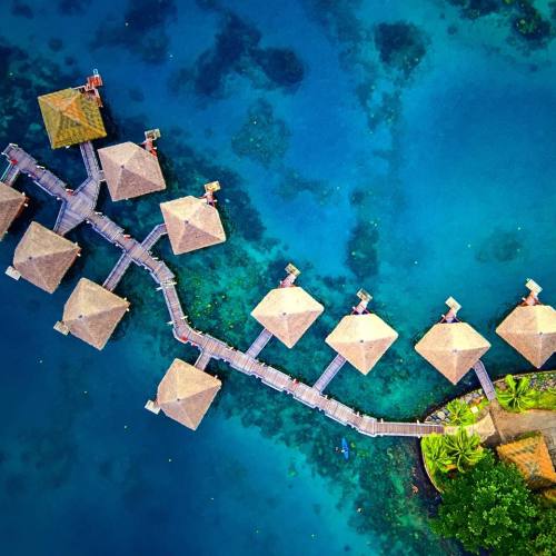 Rich turquoise waters surround Tahitian over water bungalows