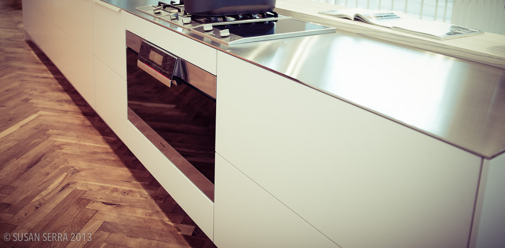 Timeless, simple, white modern kitchen paired with classic herringbone flooring. Less is more and this look is modern elegance. Uno Form showroom in Copenhagen. The precision fit countertop is perfect in its crisp and clean design.