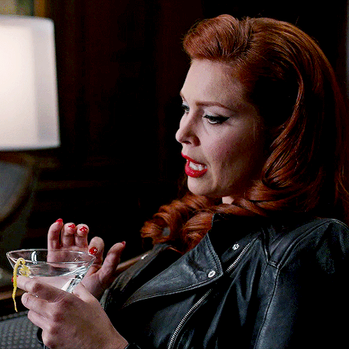 sarahblakes:ABADDON | 9×21 King of the Damned[image ID: two gifs of abaddon, wearing a black leather jacket, red lipstick, and sharp winged eyeliner. the knight of hell is sitting in an armchair at three-quarter profile with a martini in her hand. in the first gif, she laughs and smiles while touching the rim of the glass with her bright red manicure. in the second, she brings the glass to her smirking lips. /end ID] #spn ladies#supernatural