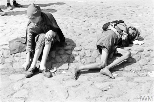 Two emaciated children, one of them asleep or unconscious, begging in the Warsaw Ghetto (Poland, 194